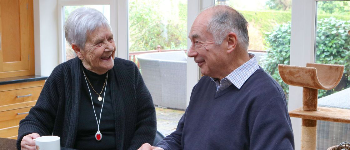 Two elderly people wearing their My Amie pendants